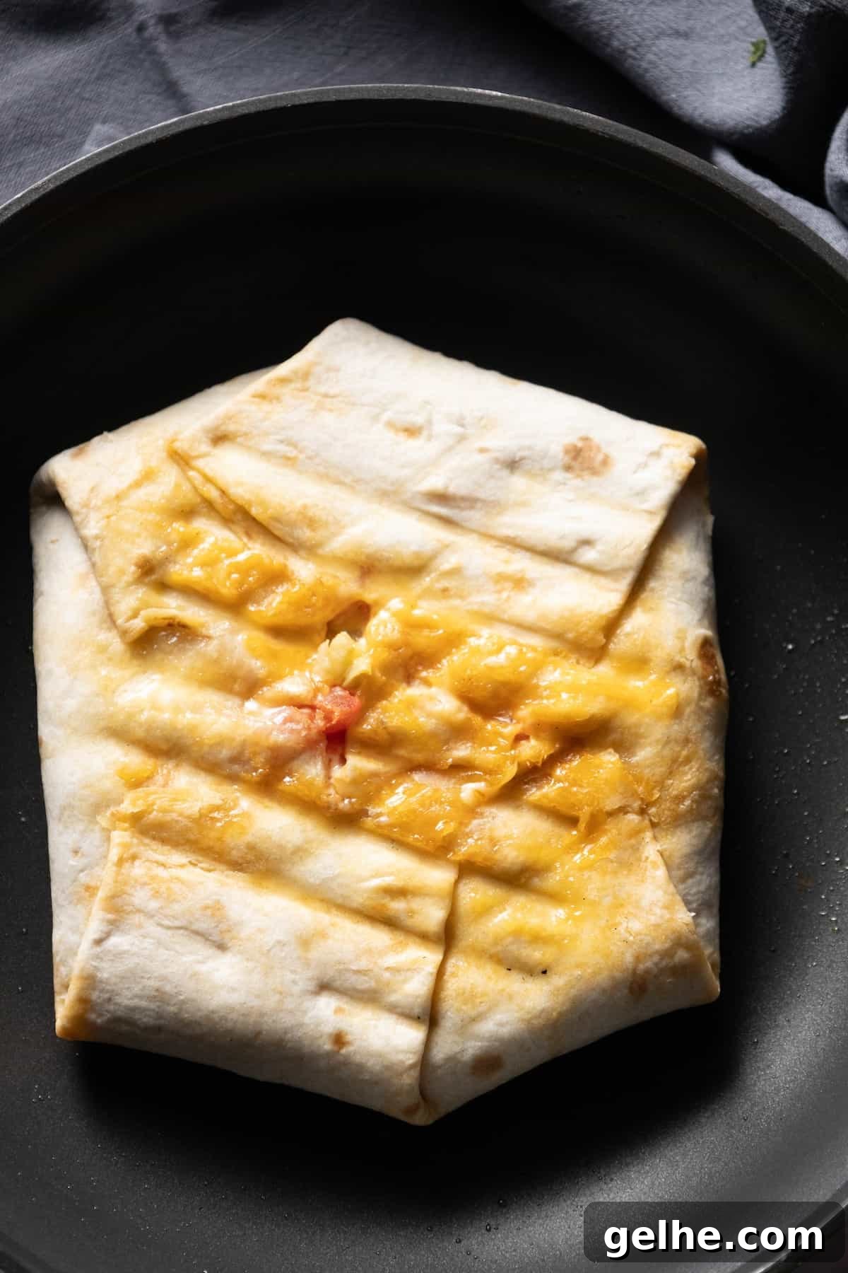 Crispy Homemade Crunchwrap Recipe: Copycat Taco Bell Wrap 11 A crunchy quesadilla in a frying pan with melted cheese, homemade.