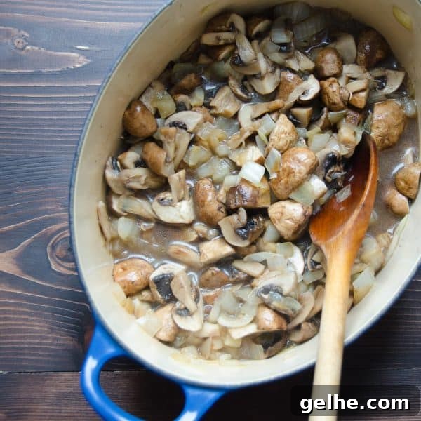 Silky Mushroom Bisque Recipe 4 mushrooms in a pot with wooden spoon
