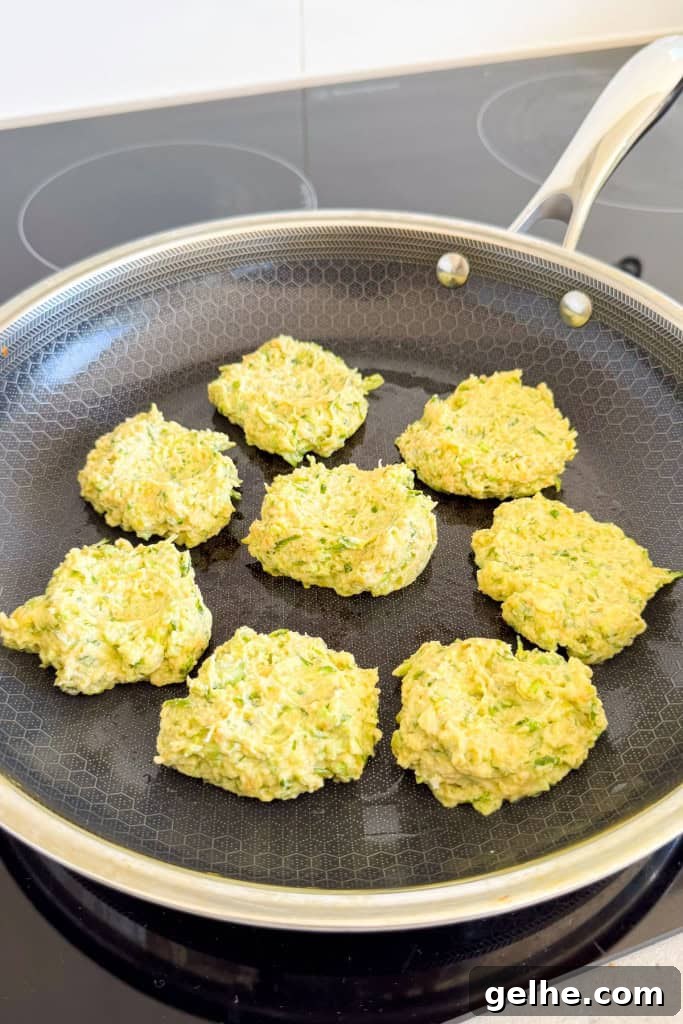 Fritters being cooked in a pan.