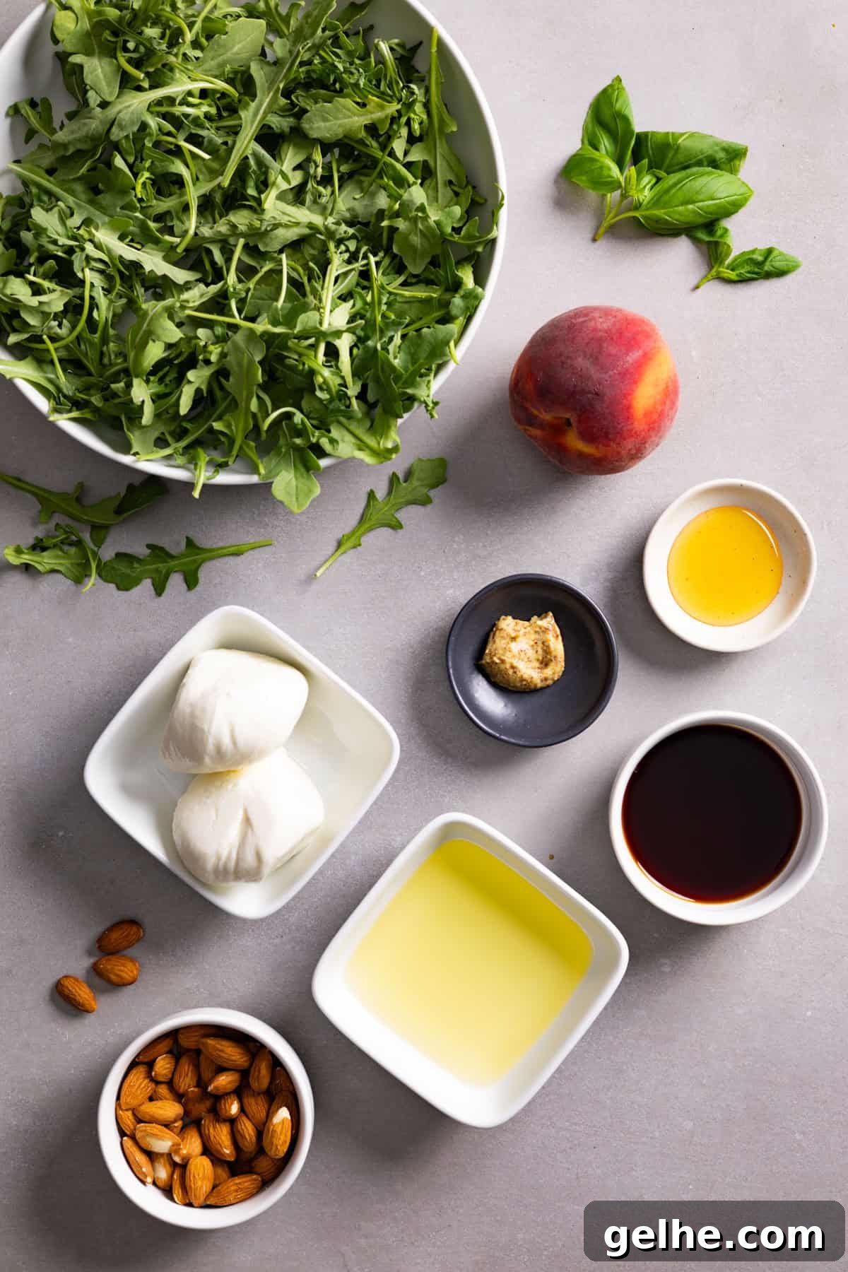Ingredients for a burrata arugula salad on a gray table.