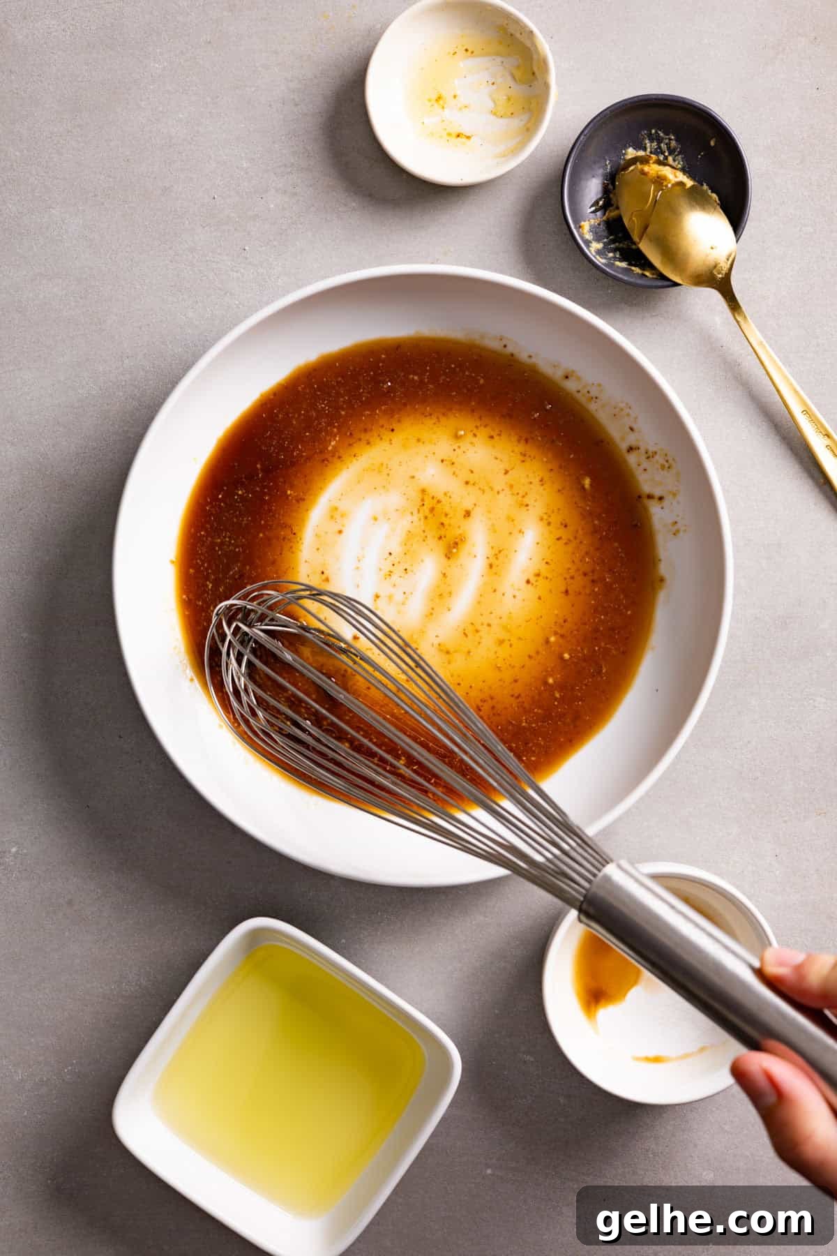 Balsamic vinaigrette whisked in a white bowl.