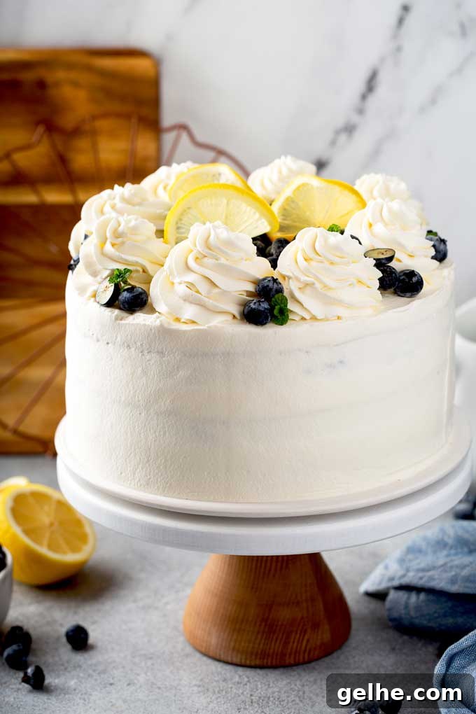 A cake covered in whipped mascarpone frosting on a cake plate.