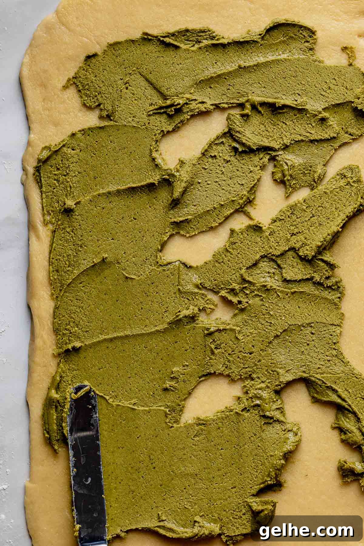 Filling spreading on the dough with a spatula.