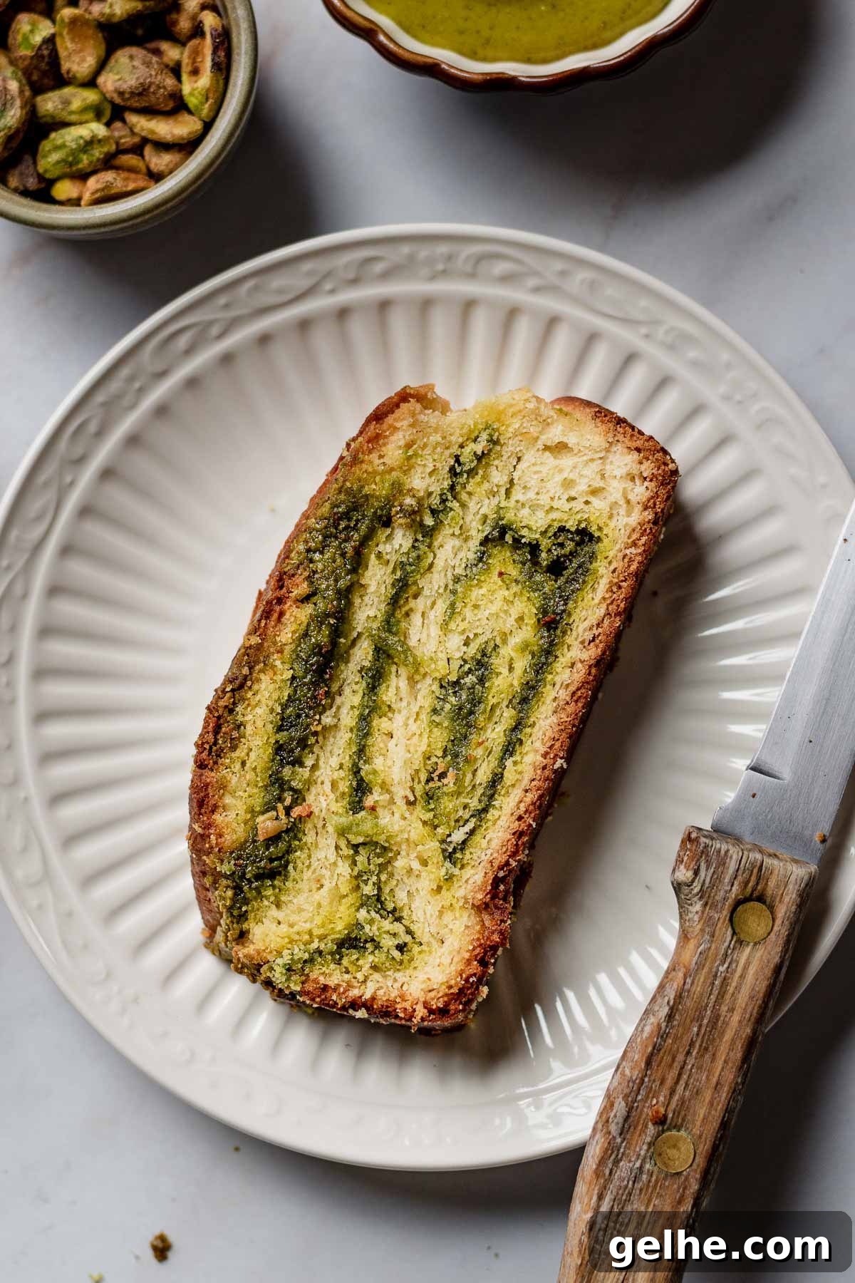 Slice of pistachio babka on a plate.