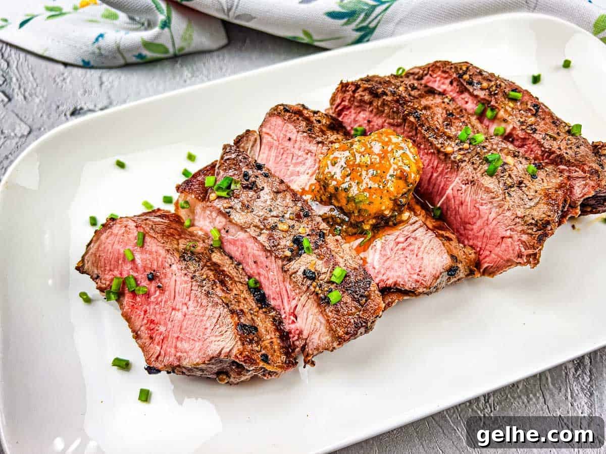 A grilled steak with cowboy butter on a white plate.