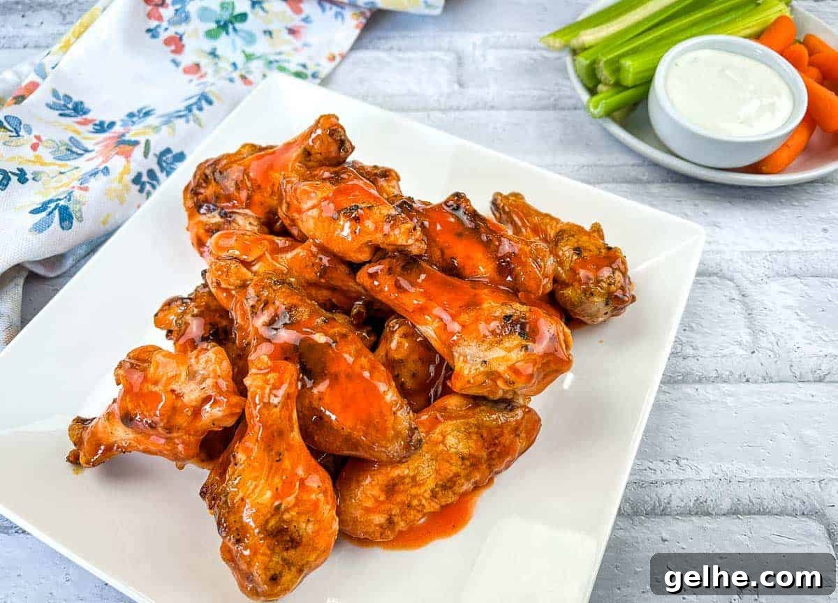 Grilled Chicken Wings with Buffalo Sauce on a white square plate.