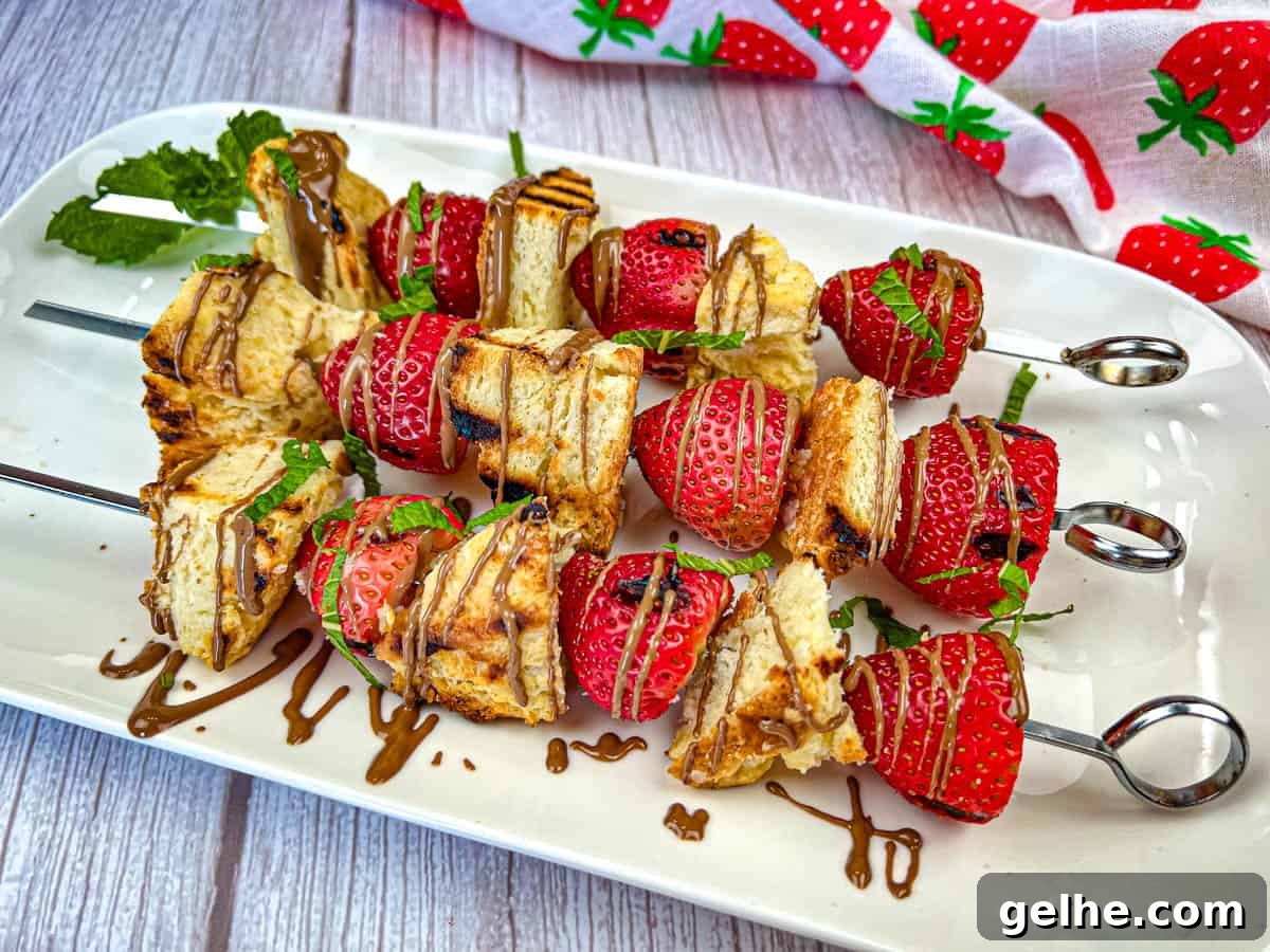 Three pieces of Grilled Strawberry Shortcake Skewers on a white plate.