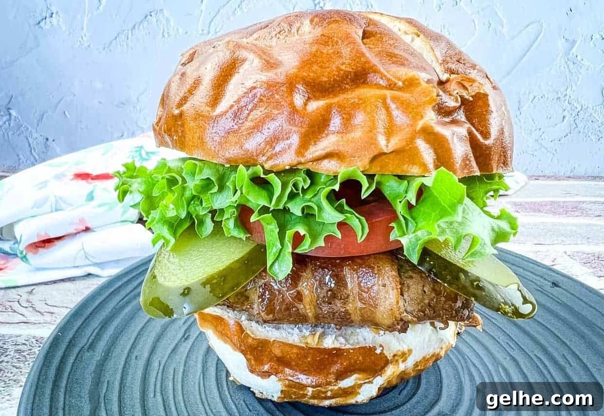 Bacon-Wrapped Burger on a black plate.