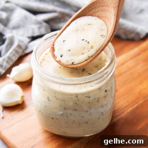 jar filled with creamy, rich garlic parmesan sauce thickened with cheese and herbs