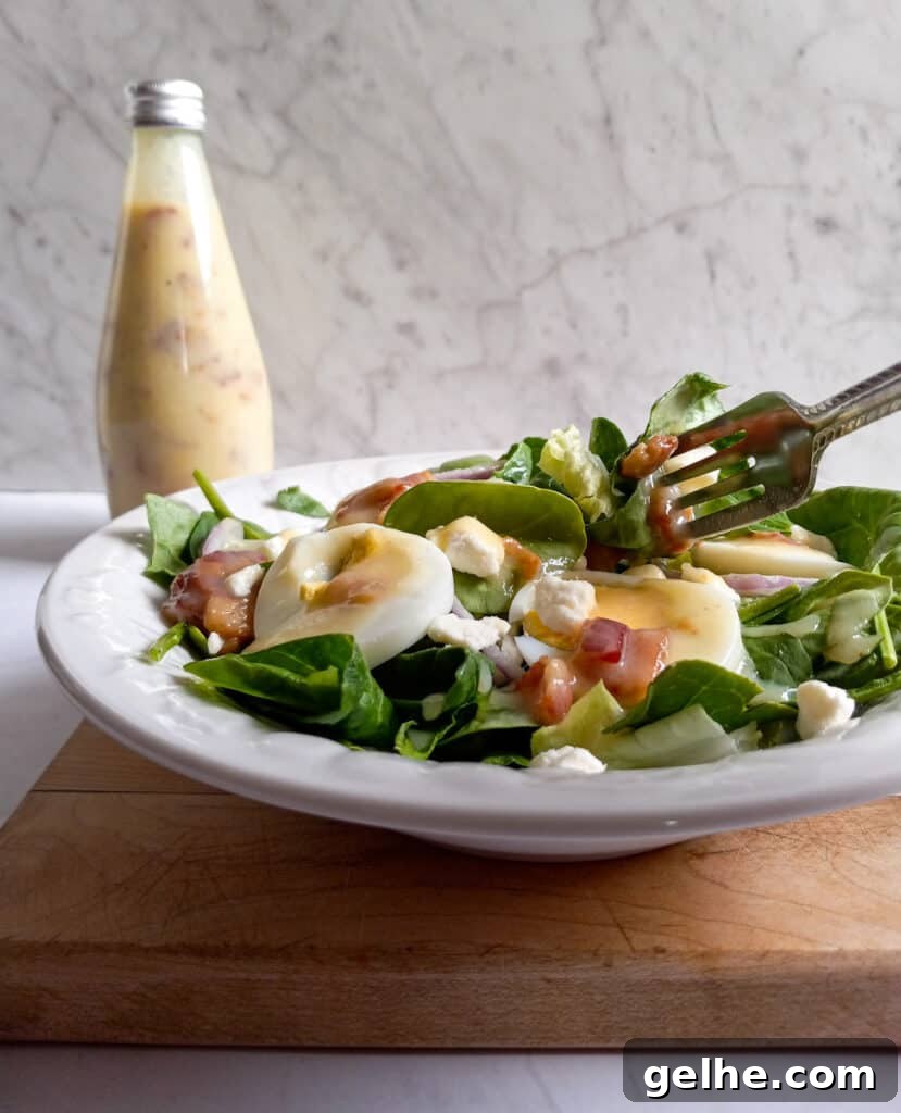 a bowl of spinach and lettuce salad with hot bacon dressing